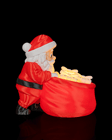 Papai Noel de perfil conferindo os presentes iluminados na sacola
